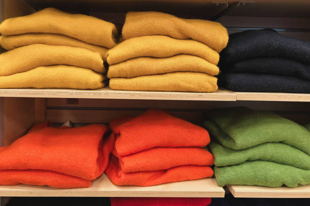 Sweaters organized on shelves at a clothing store - menswear concepts