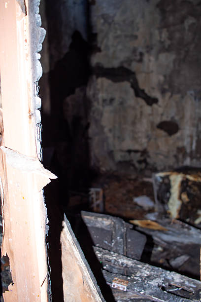 istock A dark room with a burnt out wall and a burnt out bed 2206455489