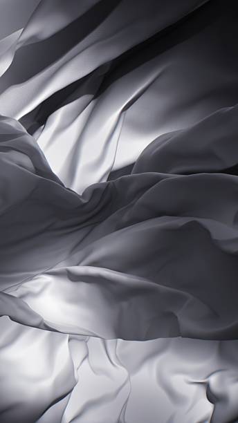 istock A swirling sheet of soft fabric dances with light in a grayscale composition. 2206455662