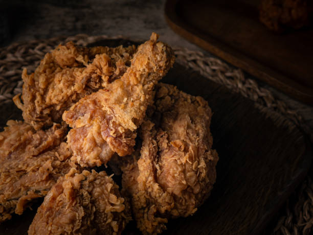 istock Crispy Fried chicken on a wooden plate Set on dark dinning table. 2206455944