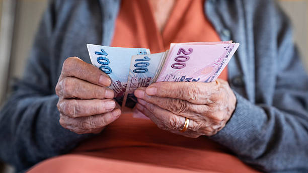 istock Old woman counting Turkish lira banknotes 2206458473