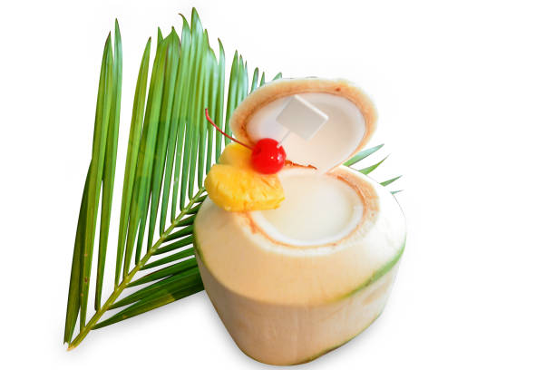 Perspective of a person enjoying coconut drink on the beach by emerald water