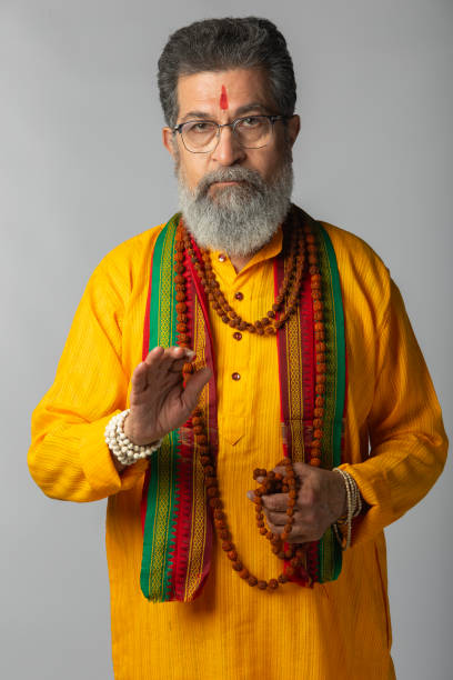 Old priest with rudraksha posing on white background