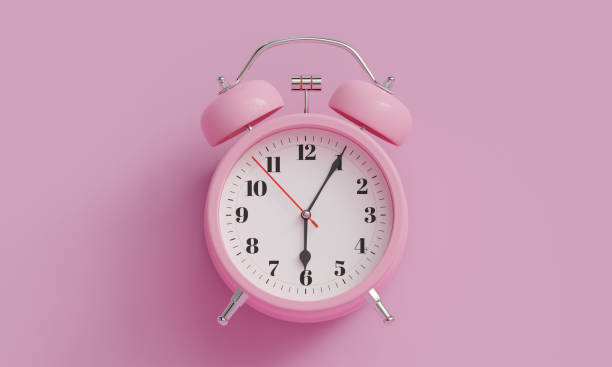 istock Pink alarm clock on pink background The clock hand shows 6 oclock 2206465842