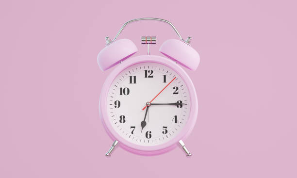 istock Pink alarm clock on pink background The clock hand shows 6.15 oclock 2206465843