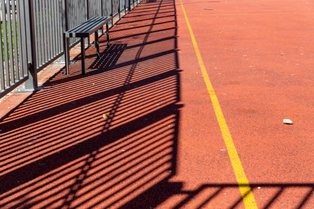 istock Sunlit school playground with bench and track lines, emphasizing active outdoor recreation and children's sports. 2206466133