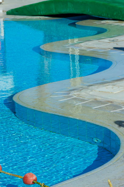 istock Curved turquoise swimming pool design with clear water reflects summer leisure and tropical relaxation vibes 2206466507