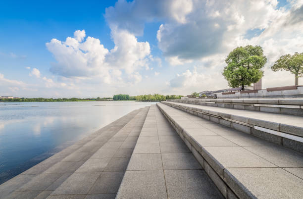 istock Serene waterfront promenade with elegant stone steps, complemented by a clear blue sky. 2206467742