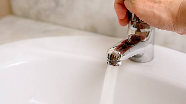 istock Hand opening water faucet, showing saving water concept 2206470595