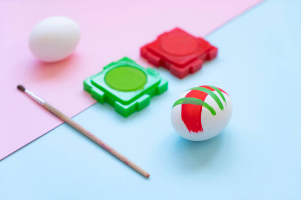 Easter holiday concept with eggs, water colors, paints on colored background.