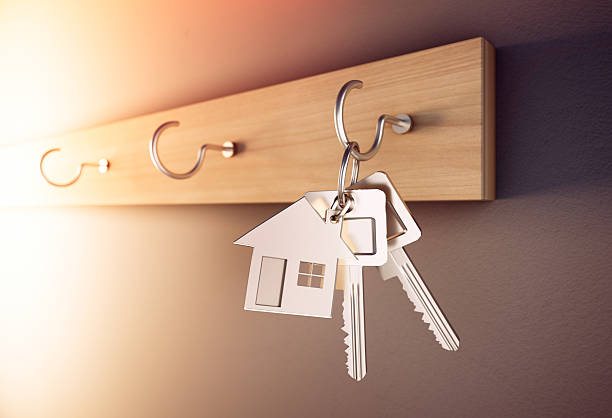 istock Key chain with keys hanging on wooden keyboard 2206473765