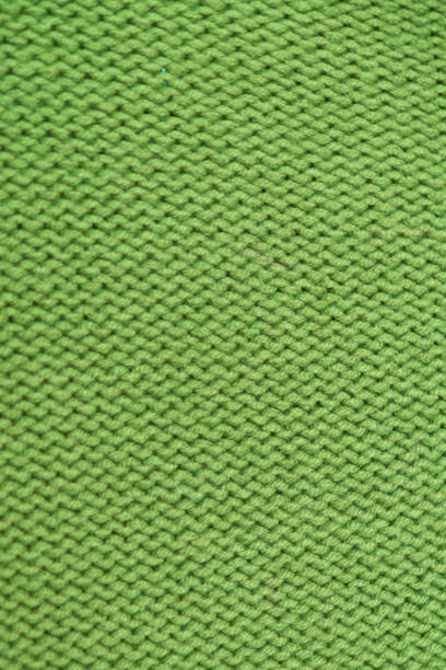 istock knitted texture, bright green sweater or carpet, pattern of the back and front loops. 2206476491