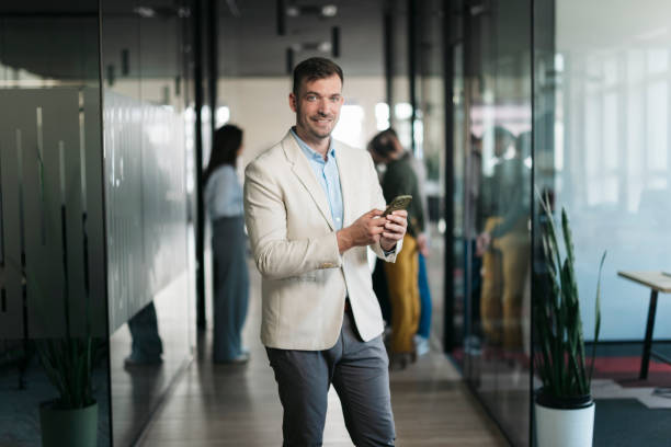 istock Businessman using smartphone in modern office corridor 2206478262