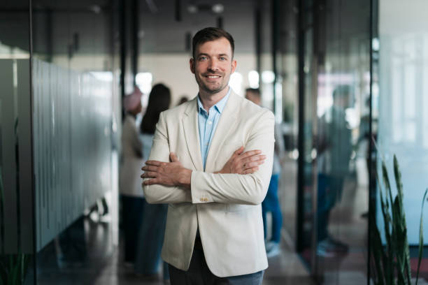 istock Confident businessman smiling with arms crossed in modern office 2206478341