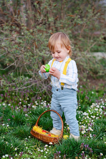 Happy little boy playing in park on Easter egg hunt
