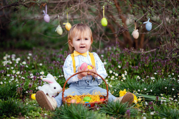 Happy little boy playing in park on Easter egg hunt