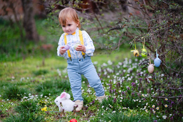 Cute little boy collecting eggs in an Easter egg hunt