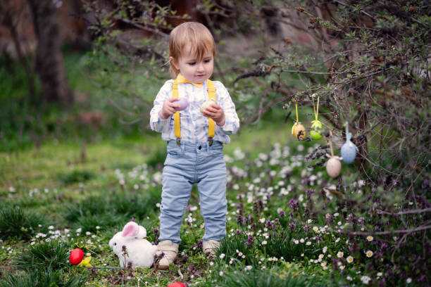 Cute little boy collecting eggs in an Easter egg hunt