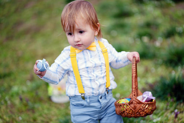 Cute little boy collecting eggs in an Easter egg hunt