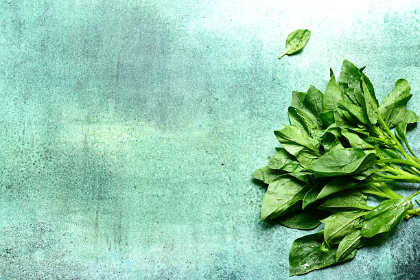 istock Fresh organic spinach leaves on a green background. Top view with copy space. 2206478785