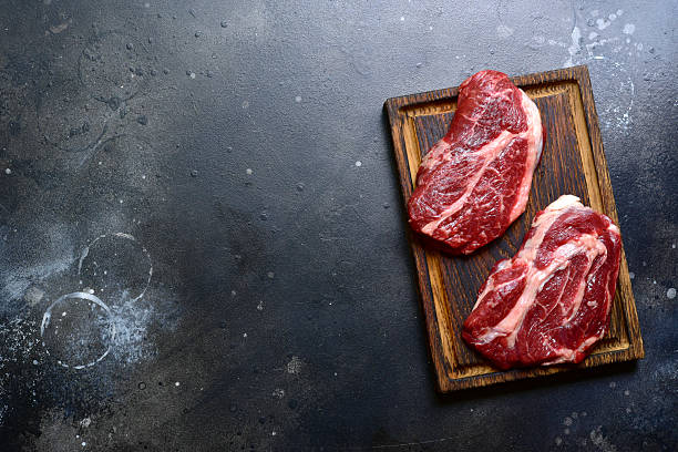 istock Raw organic marbled beef steak with ingredients for cooking . Top view with copy space. 2206478821