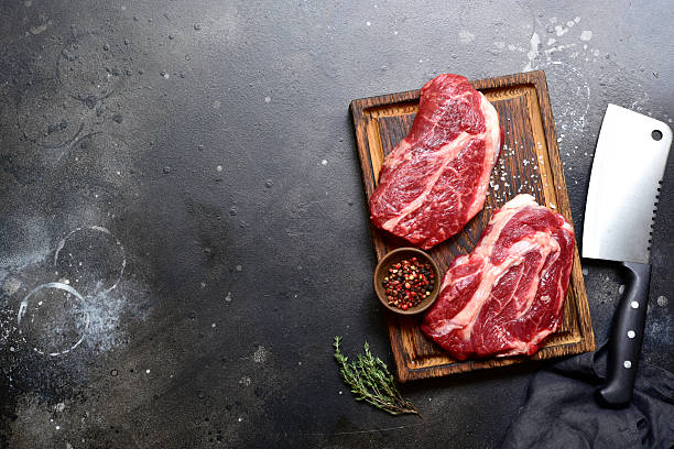 istock Raw organic marbled beef steak with ingredients for cooking . Top view with copy space. 2206478827