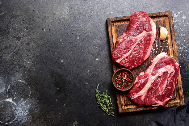 istock Raw organic marbled beef steak with ingredients for cooking . Top view with copy space. 2206479204