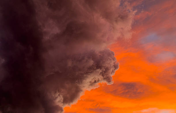 istock Crimson hues swirl between dark thunderheads. 2206479367