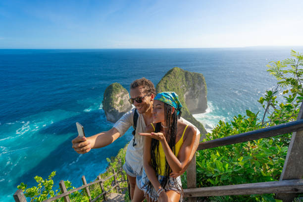 istock Couple Taking Selfie at Stunning Cliffside Viewpoint Overlooking Ocean Waves 2206487906