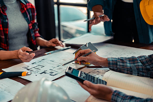 istock A team of industrial engineers meets to analyze machine blueprints. Discuss the project on the table, use the laptop to draw the building design project in the office. construction concept 2206487980