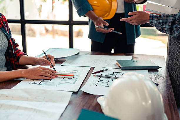 istock A team of industrial engineers meets to analyze machine blueprints. Discuss the project on the table, use the laptop to draw the building design project in the office. construction concept 2206487983