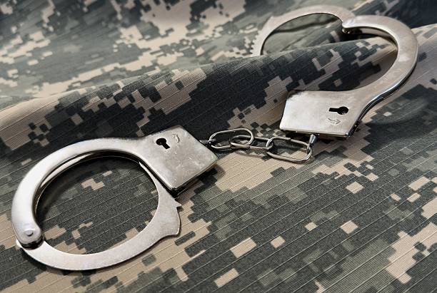 istock Handcuffs and camouflage cloth. Military, protective fabric. War crimes. 2206488423
