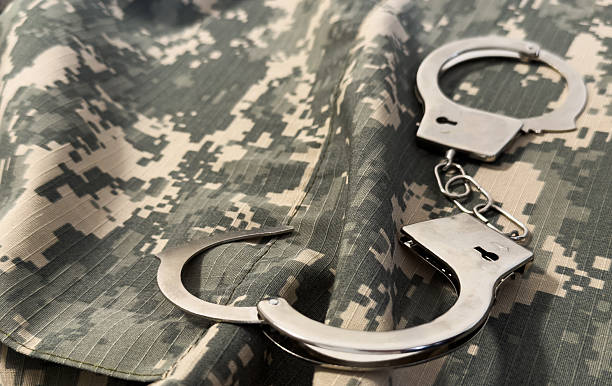 istock Handcuffs and camouflage cloth. Military, protective fabric. War crimes. 2206488431