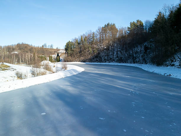 istock A serene winter landscape featuring a winding frozen river surrounded by snow-covered trees under a clear blue sky 2206489071