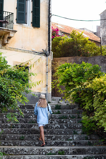 istock Traveler Resting on Old Stone Stairs Surrounded by Lush Greenery in Corfu 2206489479
