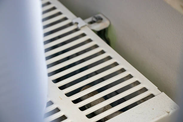 istock A close-up view of a white heating radiator showcasing its grid pattern and design. Ideal for home improvement, interior design, or real estate projects. 2206491908
