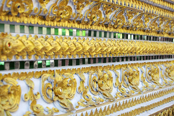 Close-up of a stunning decorative wall featuring intricate gold patterns and green tiles. The artistic design reflects cultural heritage and beauty.