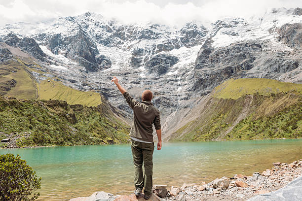 istock Man Admiring Snow-Capped Mountains by a Serene Lake 2206496461