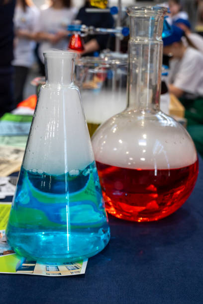 selection of chemistry laboratory glass flasks with colorful liquid - science background
