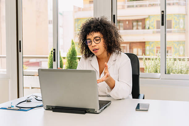 istock Hispanic Female doctor explaining diagnosis to patient during online consultation using laptop in medical office 2206497178