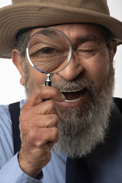 istock Detective looking through magnifying glass on white background 2206504556