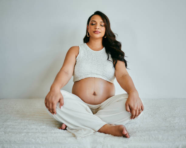 istock Pregnant Woman Meditating in Peaceful White Setting 2206504680