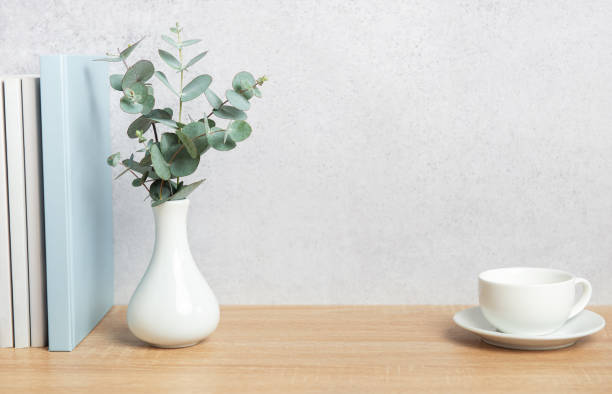 istock Eucalyptus branches, books, and coffee cup creating a cozy atmosphere on wooden desk 2206505096