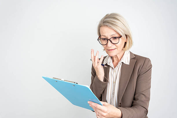 istock Businesswoman thinks, holds pen and clipboard, writing down 2206506753