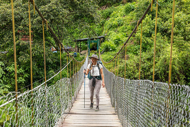 istock Hiker Crossing Rope Bridge in Lush Jungle 2206508792