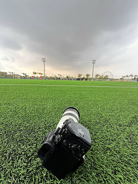 Photojournalist working at a soccer event on the field with the stadium in the background