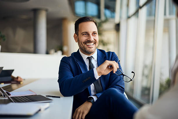 istock Smiling Businessman Holding Glasses in Modern Office Environment 2206511241