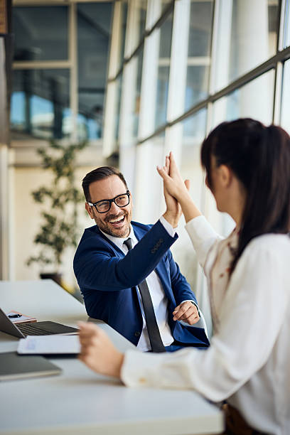 istock Colleagues Celebrating Success with a Friendly High-Five in Office Setting 2206511243