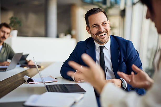 istock Smiling Businessman Engaged in a Professional Discussion at a Modern Office 2206511246
