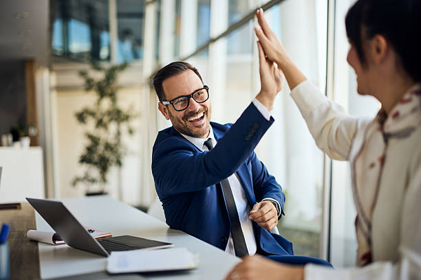 istock Two Professionals High-Fiving Together in a Bright Modern Office Environment 2206511247